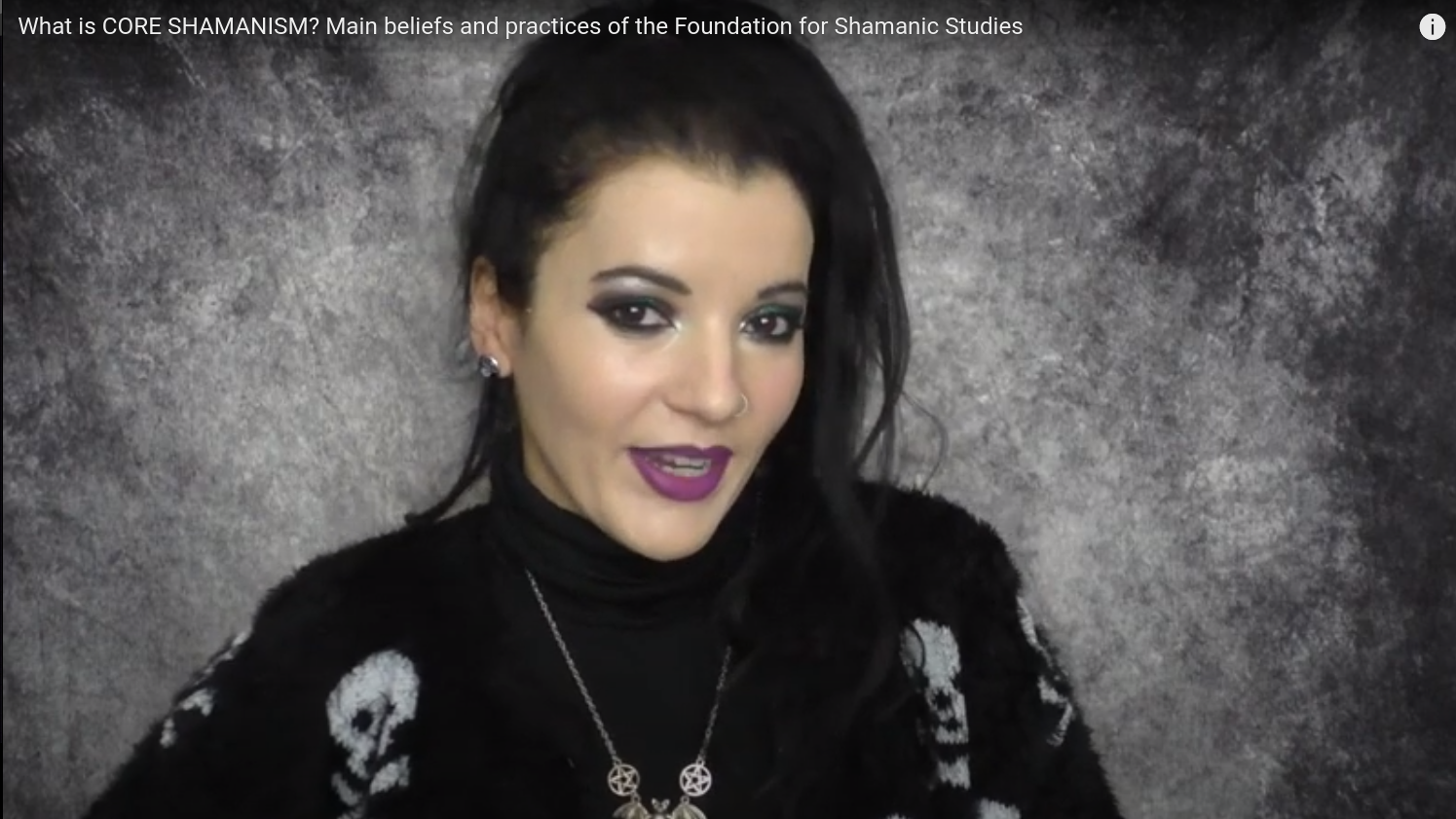 Angela wearing a black top with fuzzy skulls and a bat pendant