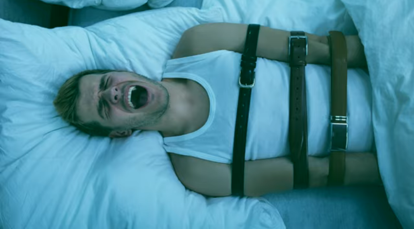 Sleep paralysis - a man bound with straps screaming