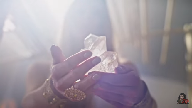 hands holding crystals - screenshot